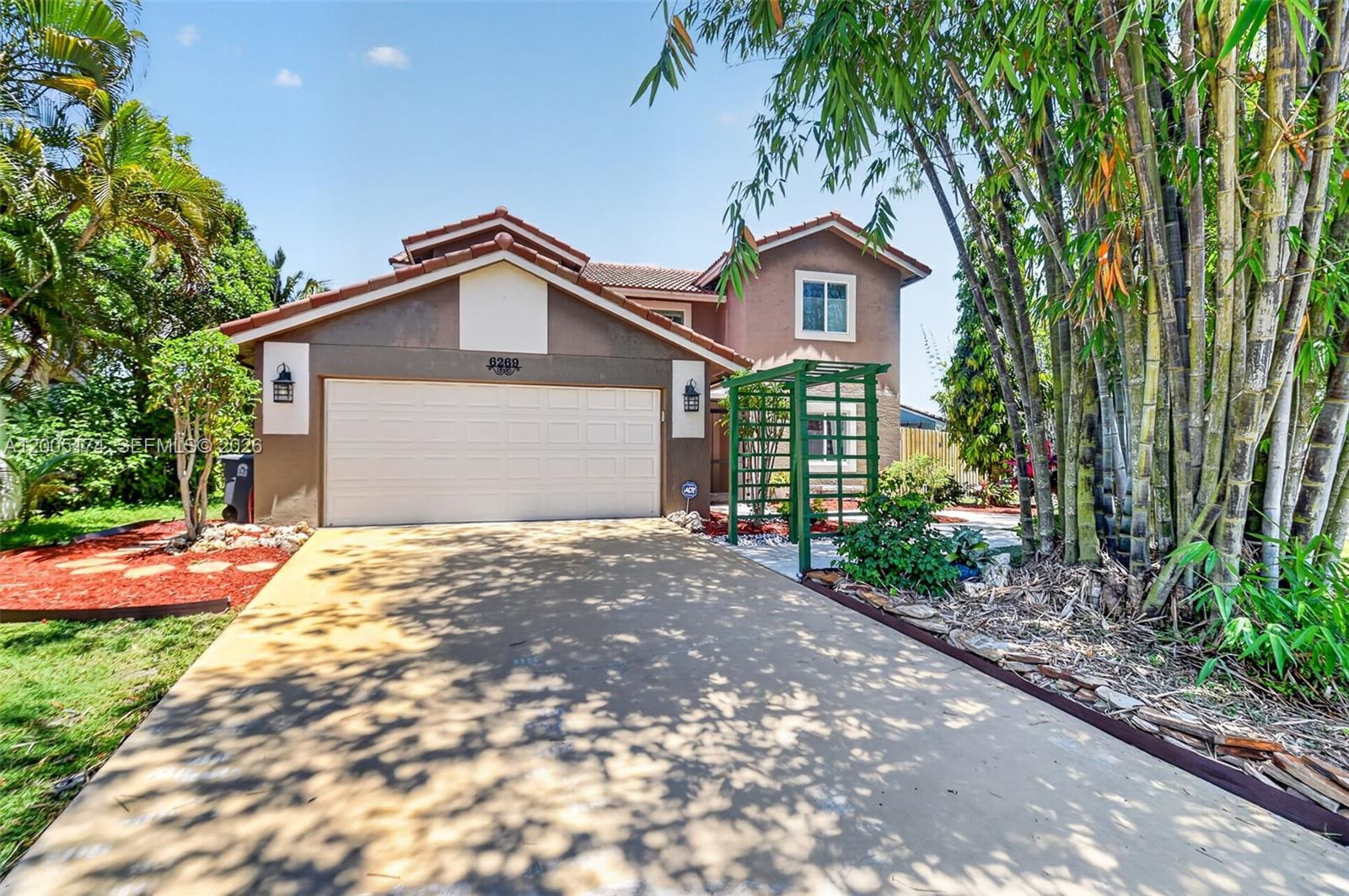 A two-story house with a brown stucco exterior, a two-car garage, and a green trellis — 6269 Country Fair Circle, Boynton Beach FL 33437, BOYNTON BEACH, FL