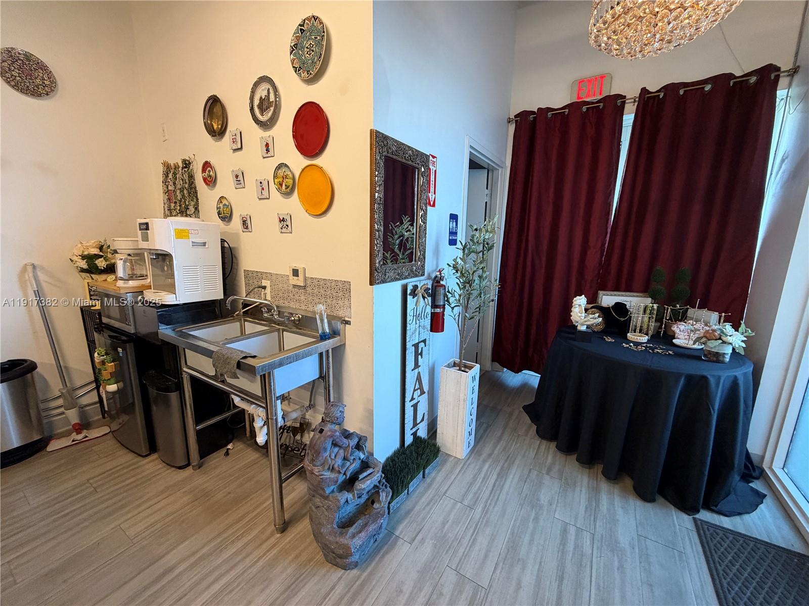 A small kitchen area with a stainless steel sink and wall-mounted decorative plates — 2201 Palm Ave, Miramar FL 33025, MIRAMAR, FL