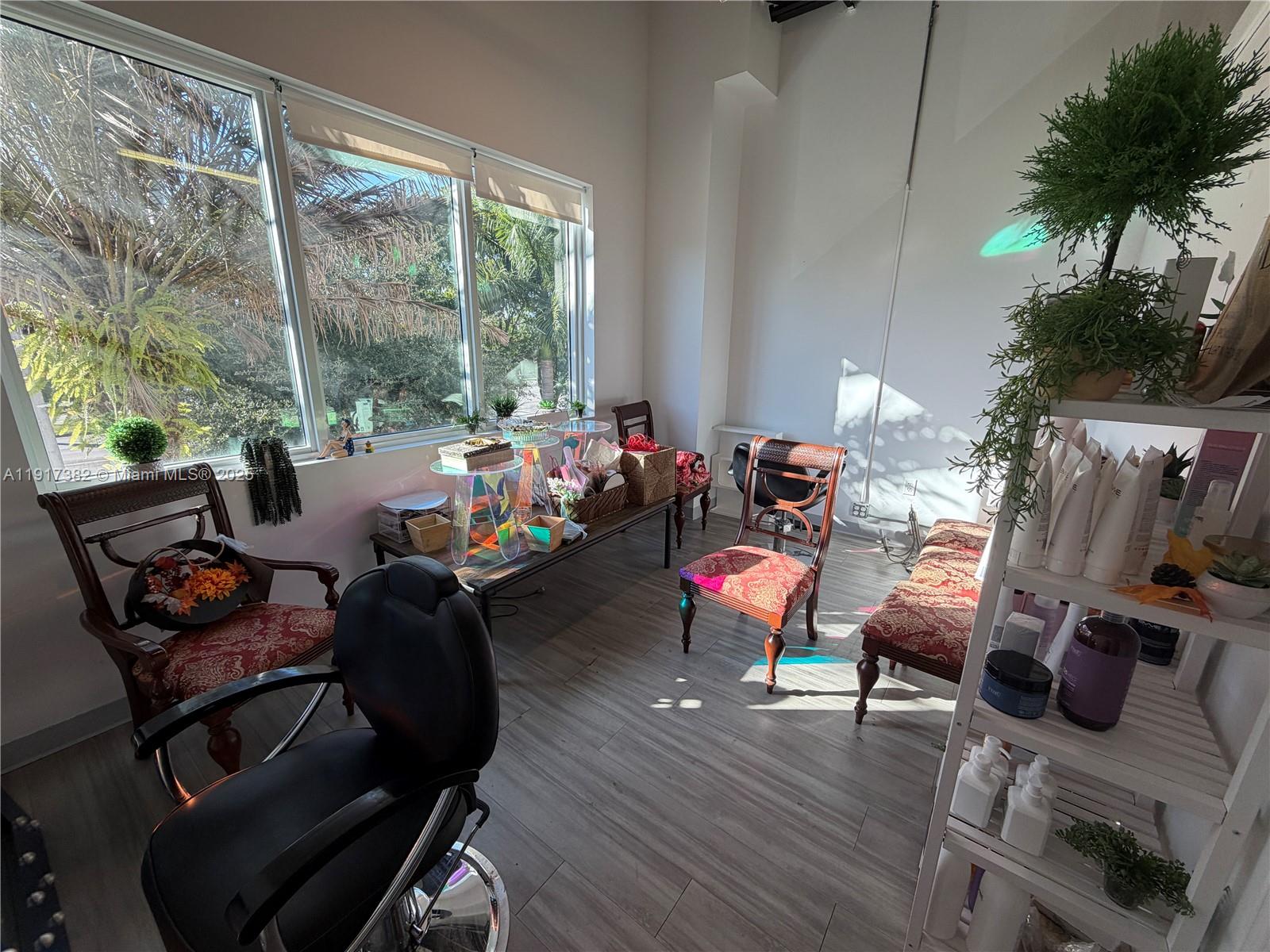 A salon room features a black styling chair, vintage-style chairs, and a white shelving unit — 2201 Palm Ave, Miramar FL 33025, MIRAMAR, FL
