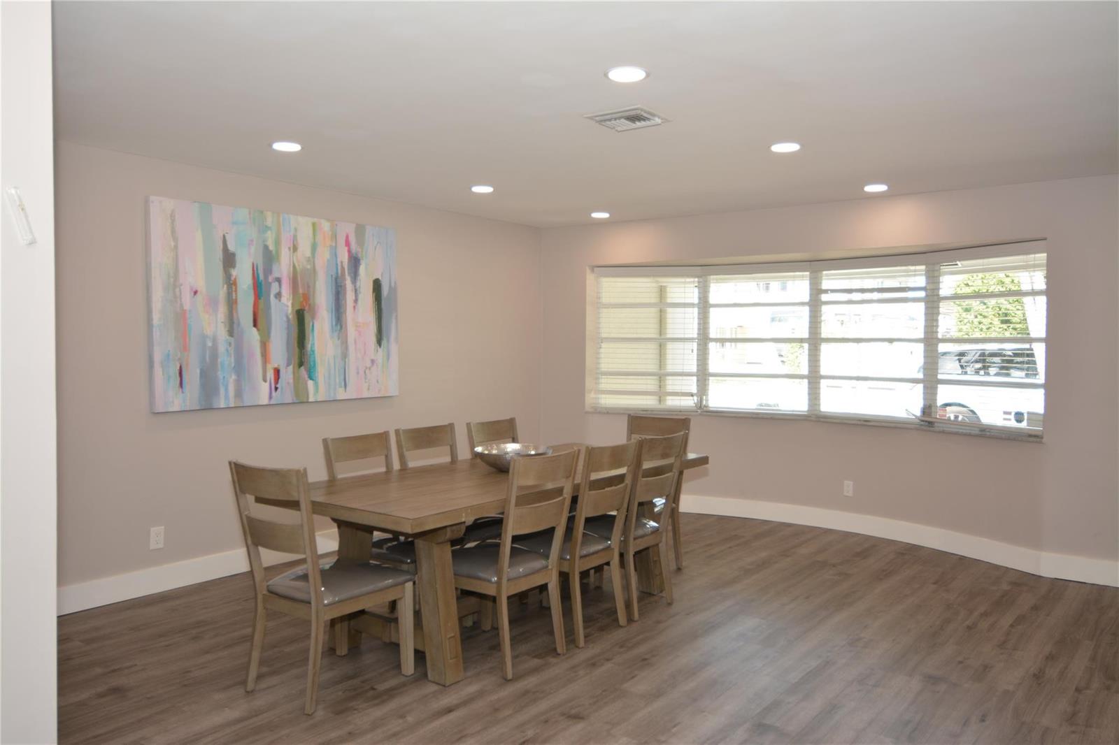 A dining room features a wooden table with six chairs, light walls, and wood-look flooring — 3840 N 42nd Terrace, Hollywood FL 33021, HOLLYWOOD, FL