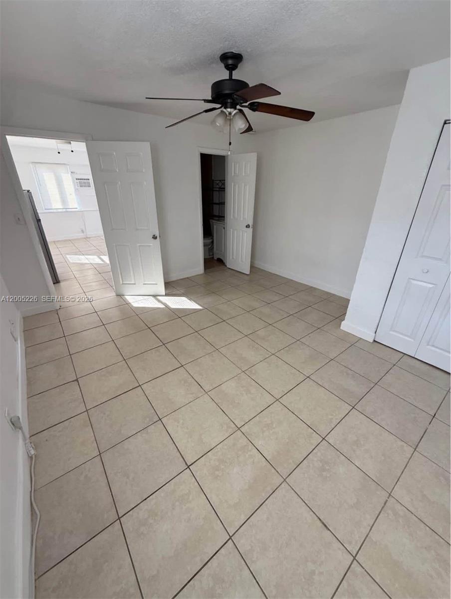 A room with light-colored tile flooring, a ceiling fan, and two open doorways — 5731 Flagler St # 1, Hollywood FL 33023, HOLLYWOOD, FL