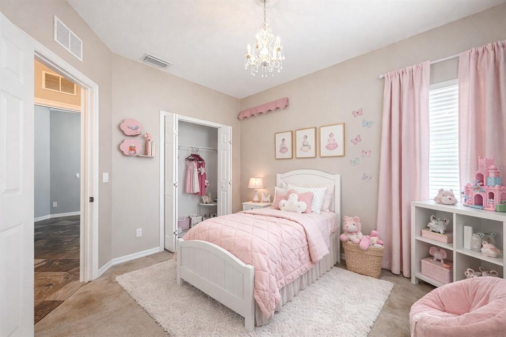A girl's bedroom features a white bed, pink bedding, a chandelier, and a white bookshelf — 12805 SW 64TH LANE, OCALA, FL