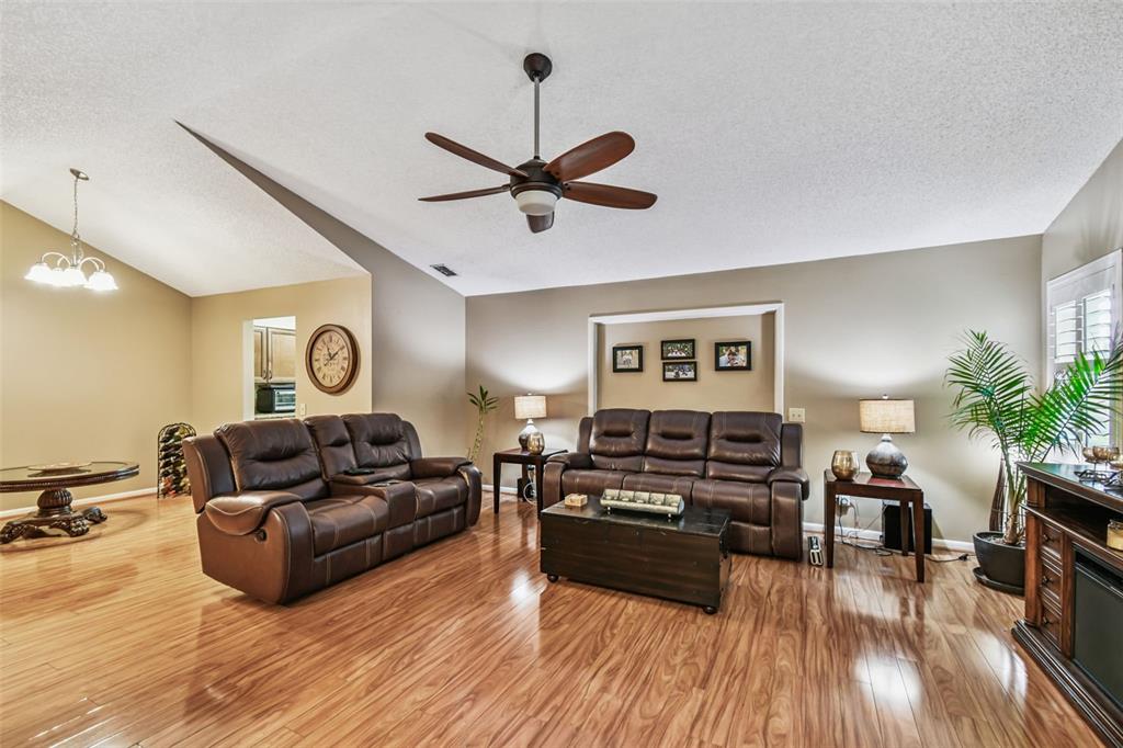 A living room features brown leather sofas, a wooden coffee table, and hardwood flooring — 2817 WINGFOOT COURT, WINTER HAVEN, FL