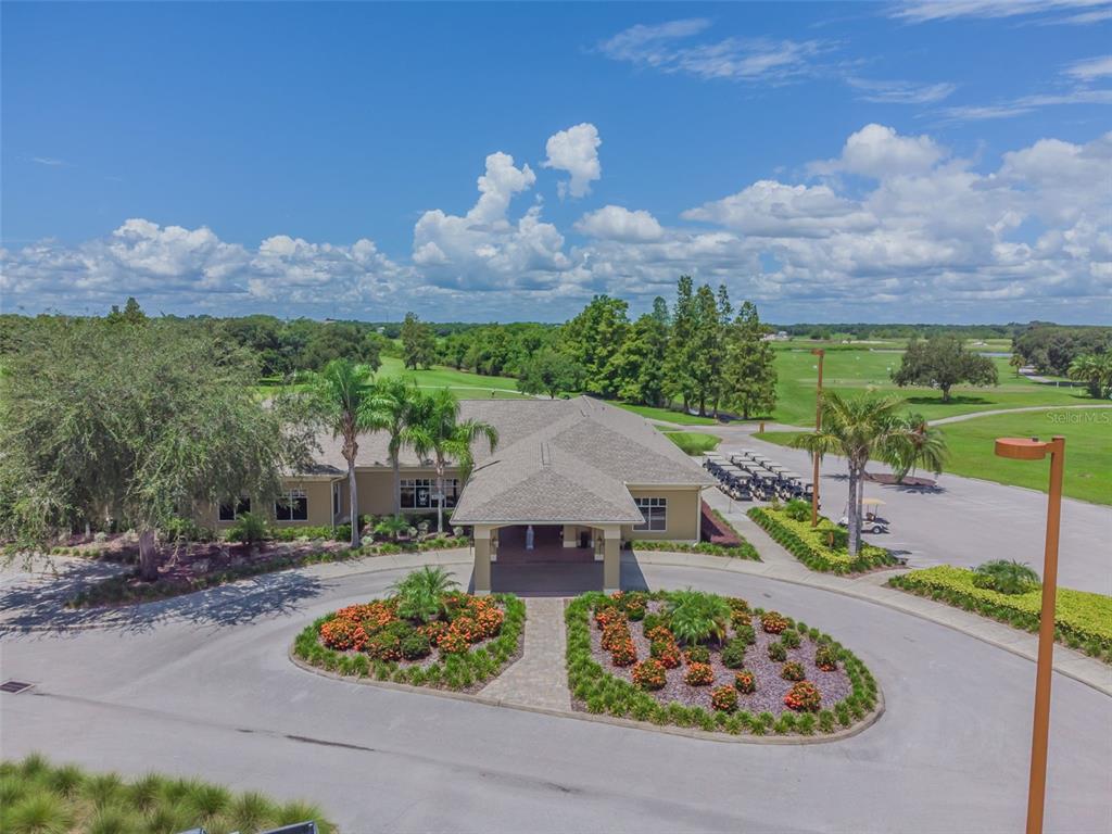 An aerial view shows a clubhouse with a circular driveway, landscaping, and a golf course — 2817 WINGFOOT COURT, WINTER HAVEN, FL
