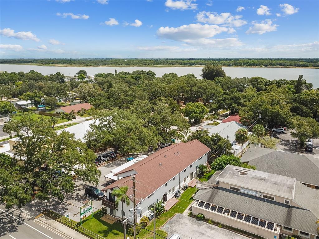 An aerial view shows a multi-story building with a brown roof near a large lake — 8423 SEMINOLE BLVD UNIT 203, SEMINOLE, FL
