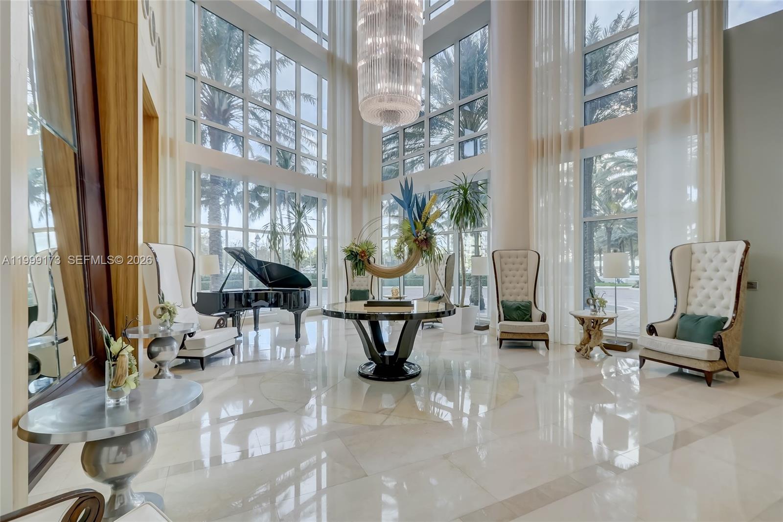 A grand lobby features floor-to-ceiling windows, a large chandelier, a piano, and marble flooring — 1 N Ocean Blvd # 1408, Pompano Beach FL 33062, POMPANO BEACH, FL