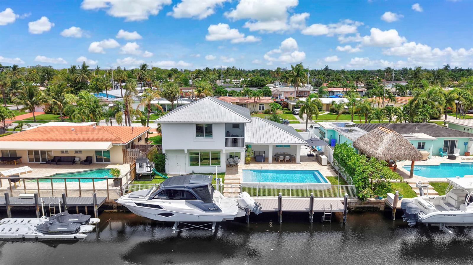 An aerial view of a waterfront house with a pool, boat lift, and private dock — 120 SE 12th Court, Pompano Beach FL 33060, POMPANO BEACH, FL