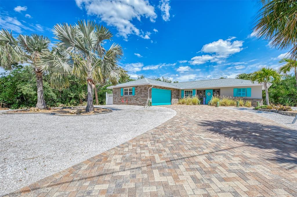 A single-story house with a stone facade, turquoise accents, and a paved driveway — 307 AVENIDA DE PARADISIO, SARASOTA, FL