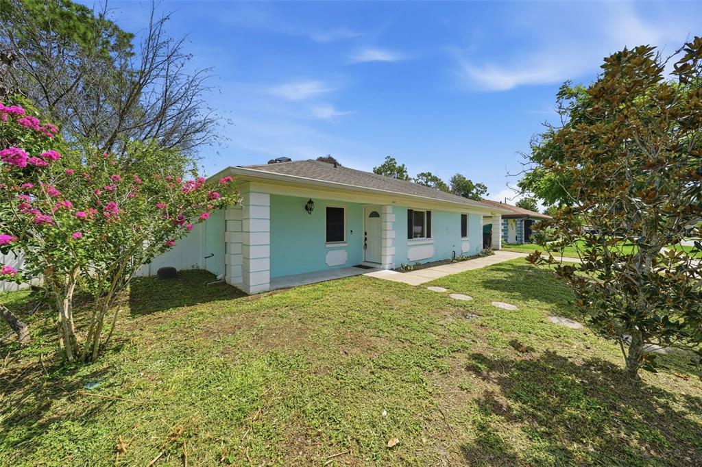 A light blue single-story house with white trim and a front walkway sits on grass — 917 ALABAMA WOODS LANE, ORLANDO, FL