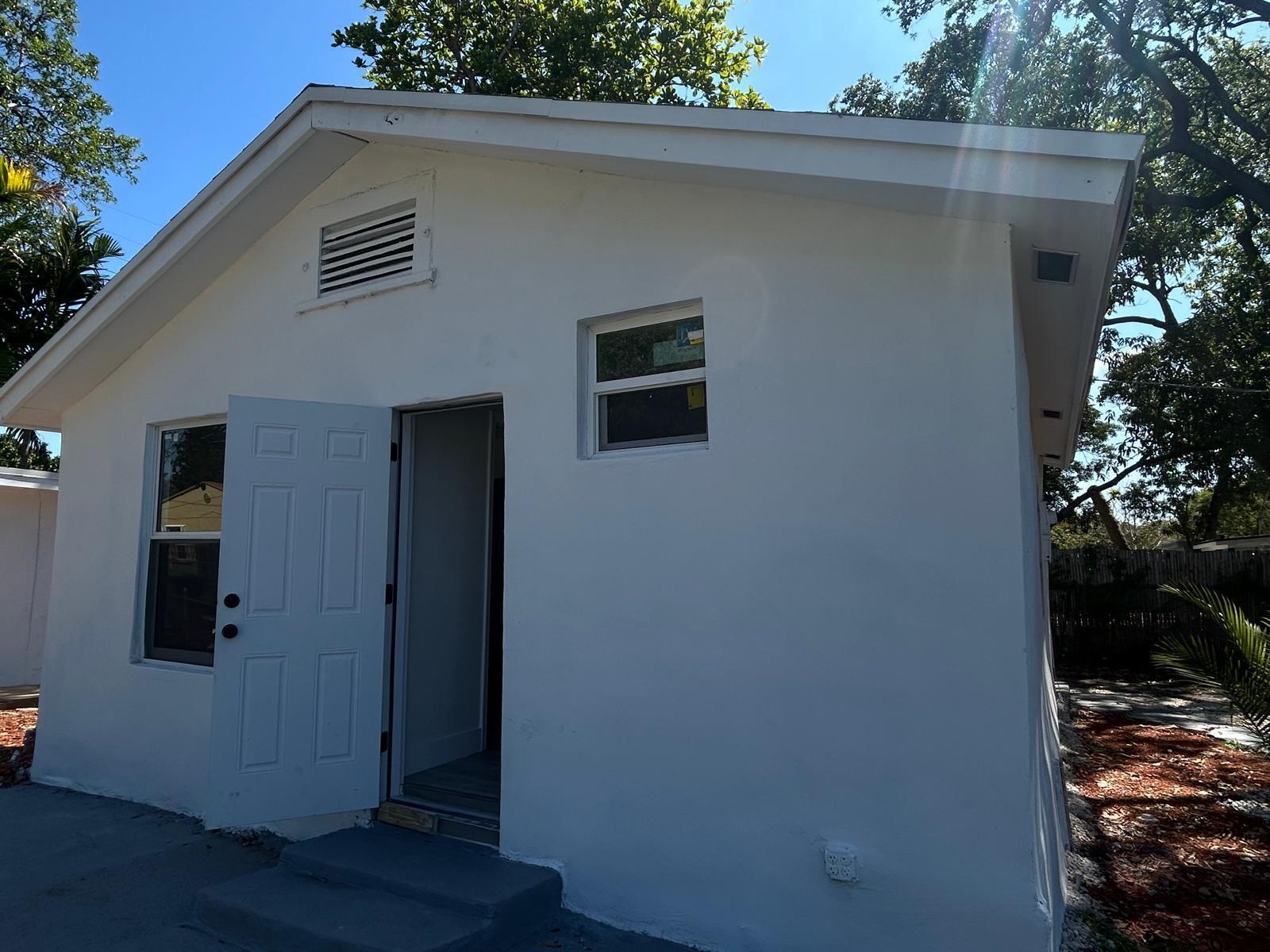 Exterior view of a white detached building with a door, two windows, and a vent — 1063 NW 55th Terrace, Miami FL 33127, MIAMI, FL