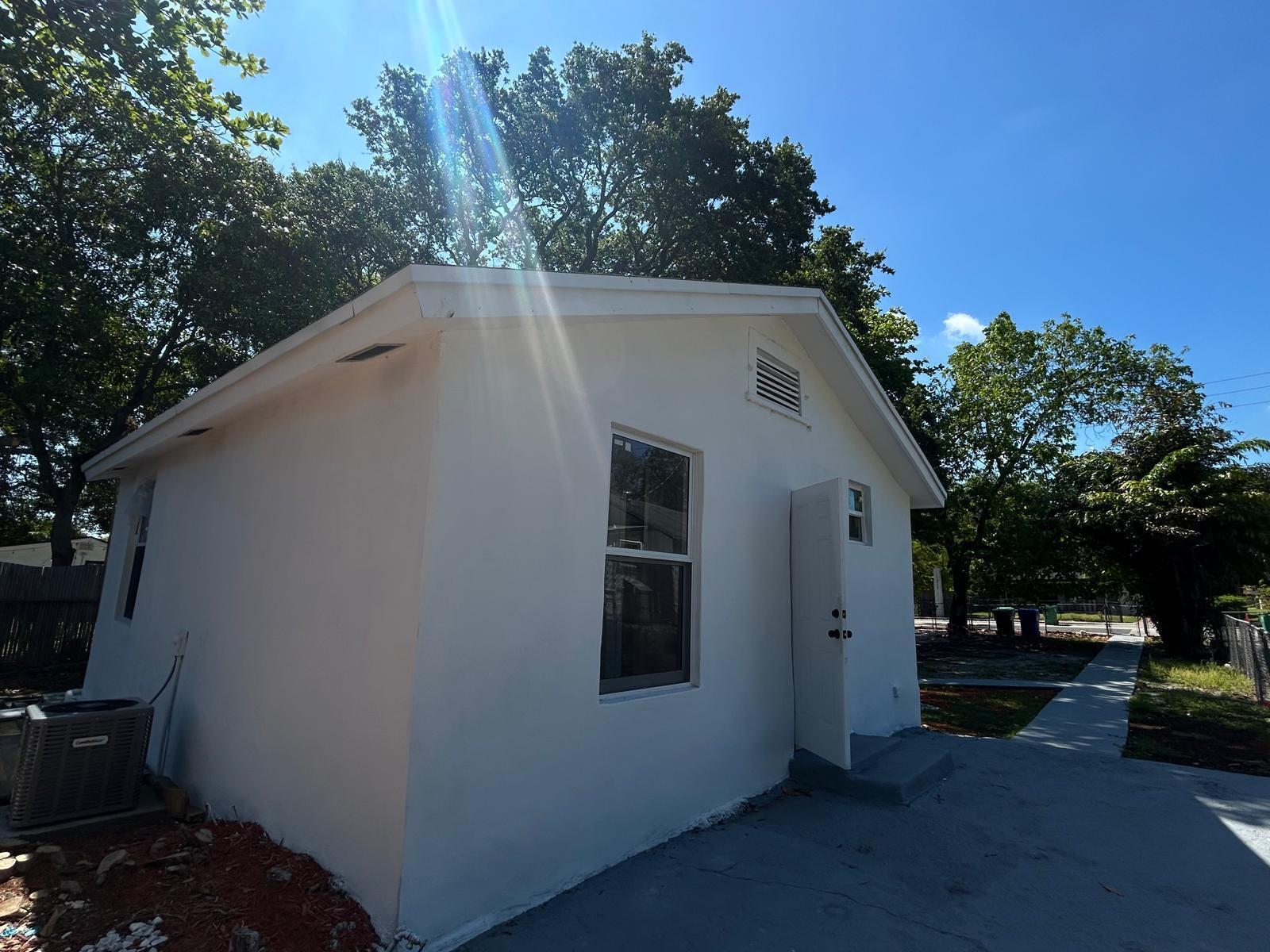 A white, single-story detached building with a window, a door, and an exterior AC unit — 1063 NW 55th Terrace, Miami FL 33127, MIAMI, FL