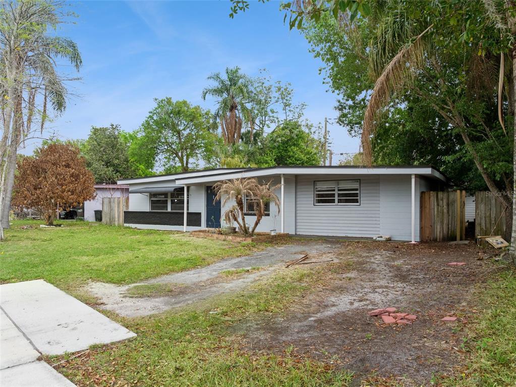 A single-story house with a light gray exterior, a flat roof, and a dirt driveway — 617 BEVERLY AVENUE, ALTAMONTE SPRINGS, FL