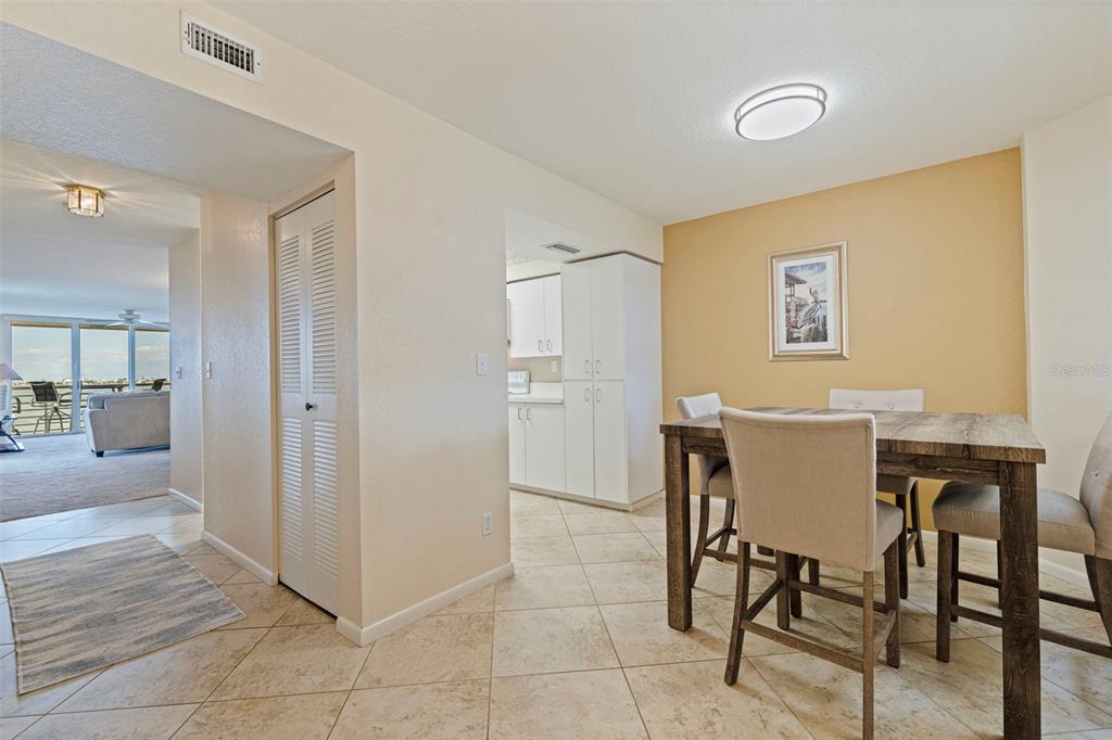 A dining area with a wooden table and chairs sits adjacent to a kitchen doorway — 6105 BAHIA DEL MAR CIRCLE UNIT 683, ST PETERSBURG, FL