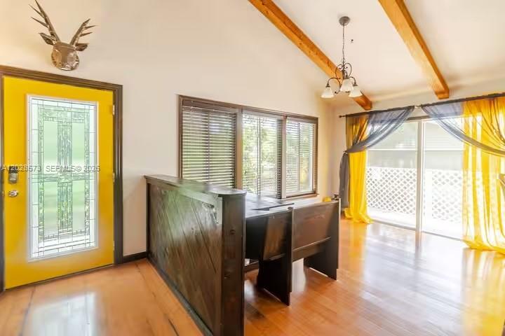 A room with a yellow door, wood floors, a dark wood partition, and vaulted ceilings — 12876 N 154th Rd N # A, Jupiter FL 33478, JUPITER, FL