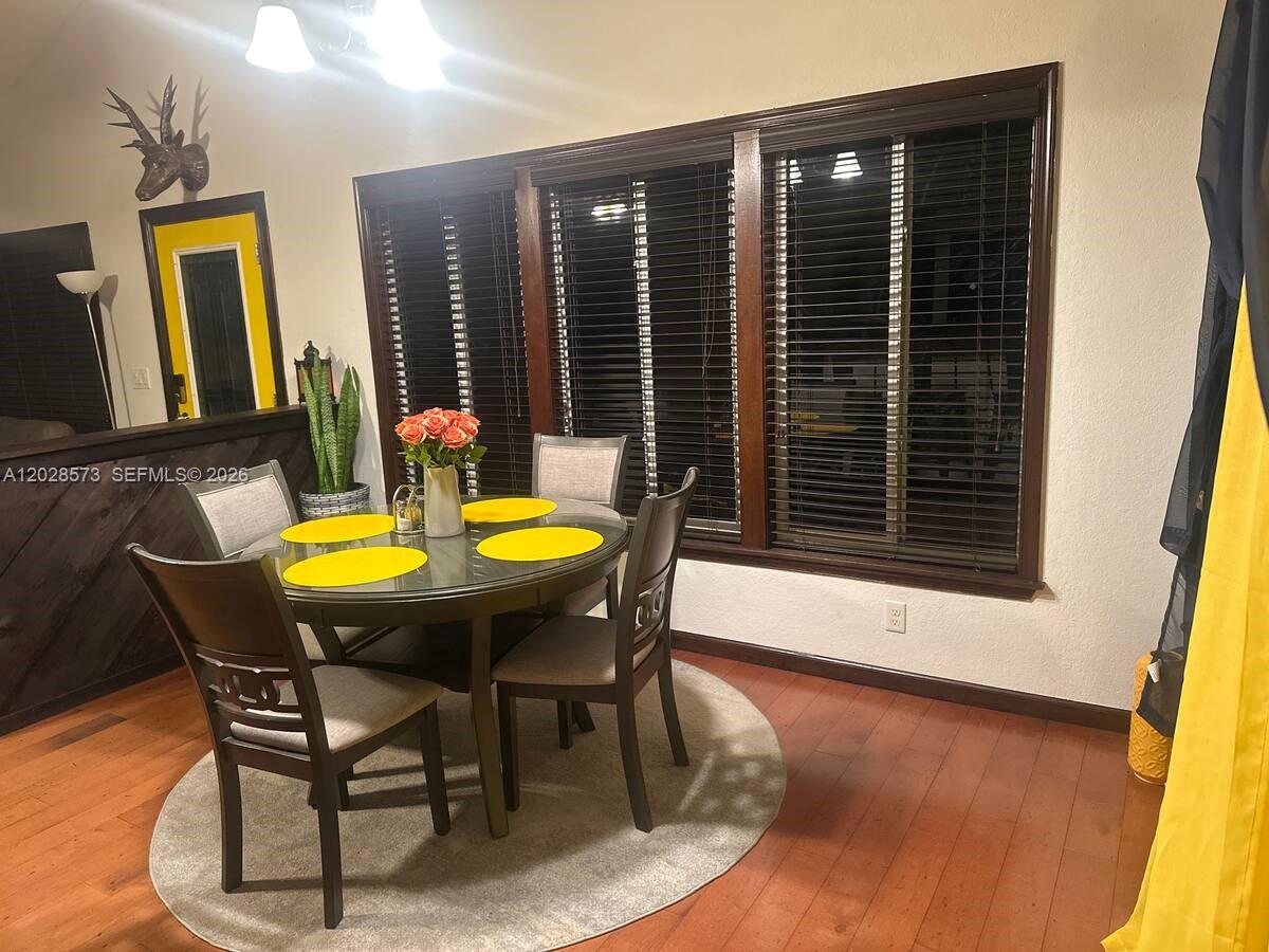 A dining room features a round table with four chairs, a rug, and large windows — 12876 N 154th Rd N # A, Jupiter FL 33478, JUPITER, FL
