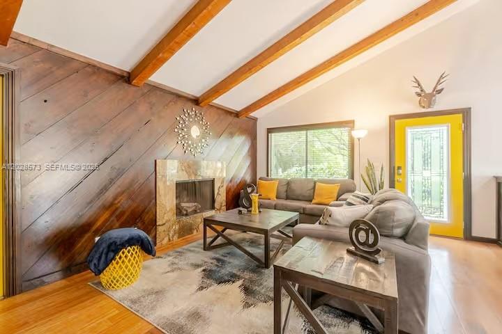 A living room features a wood-paneled wall, exposed ceiling beams, a fireplace, and yellow door — 12876 N 154th Rd N # A, Jupiter FL 33478, JUPITER, FL