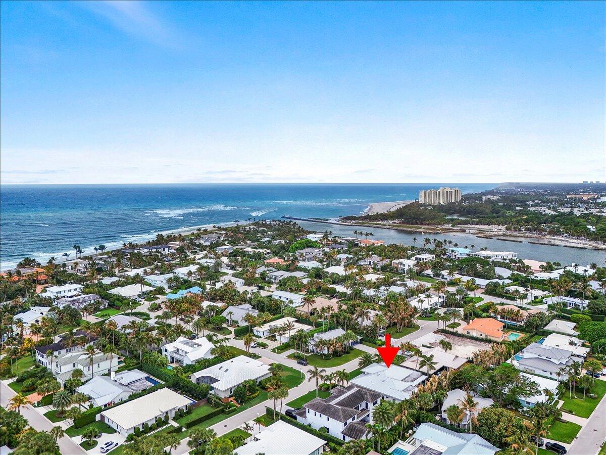 An aerial view of a coastal residential neighborhood with a red arrow pointing to a house — 187 Shelter Lane, Jupiter FL 33469, JUPITER, FL