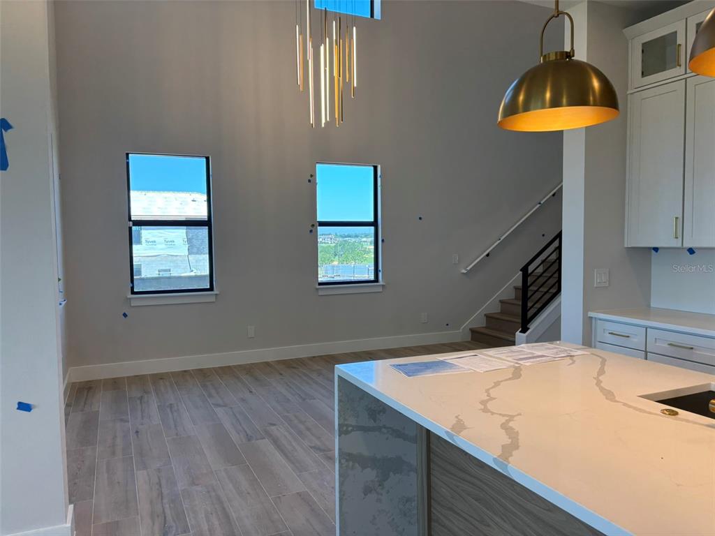 A modern living room features a fireplace, a large sectional sofa, and sliding glass doors — 16308 VETTA DRIVE, MONTVERDE, FL