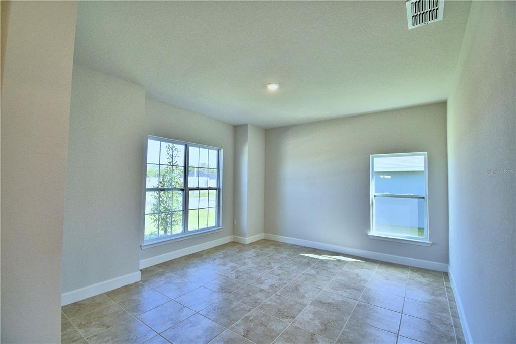 An empty room features light-colored walls, tile flooring, and two windows — 4615 CALAMINT LANE, AUBURNDALE, FL