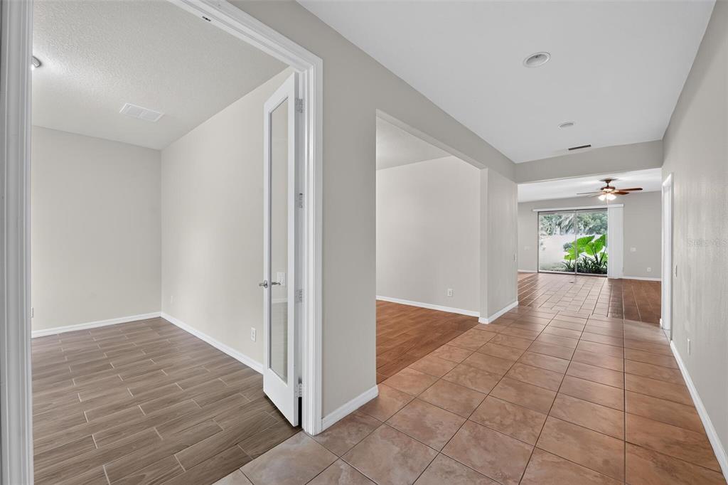 A tiled hallway leads to a room with French doors and a view of the backyard — 2130 LANDSIDE DRIVE, VALRICO, FL