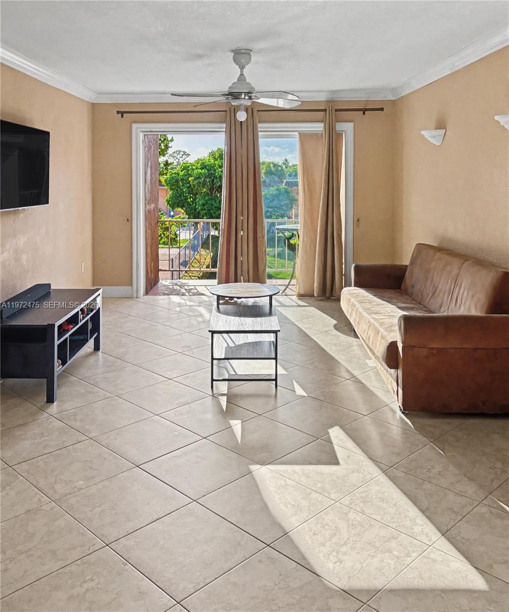 A living room features beige walls, tile flooring, a brown sofa, and a balcony door — 9417 SW 76th St # X36, Miami FL 33173, MIAMI, FL