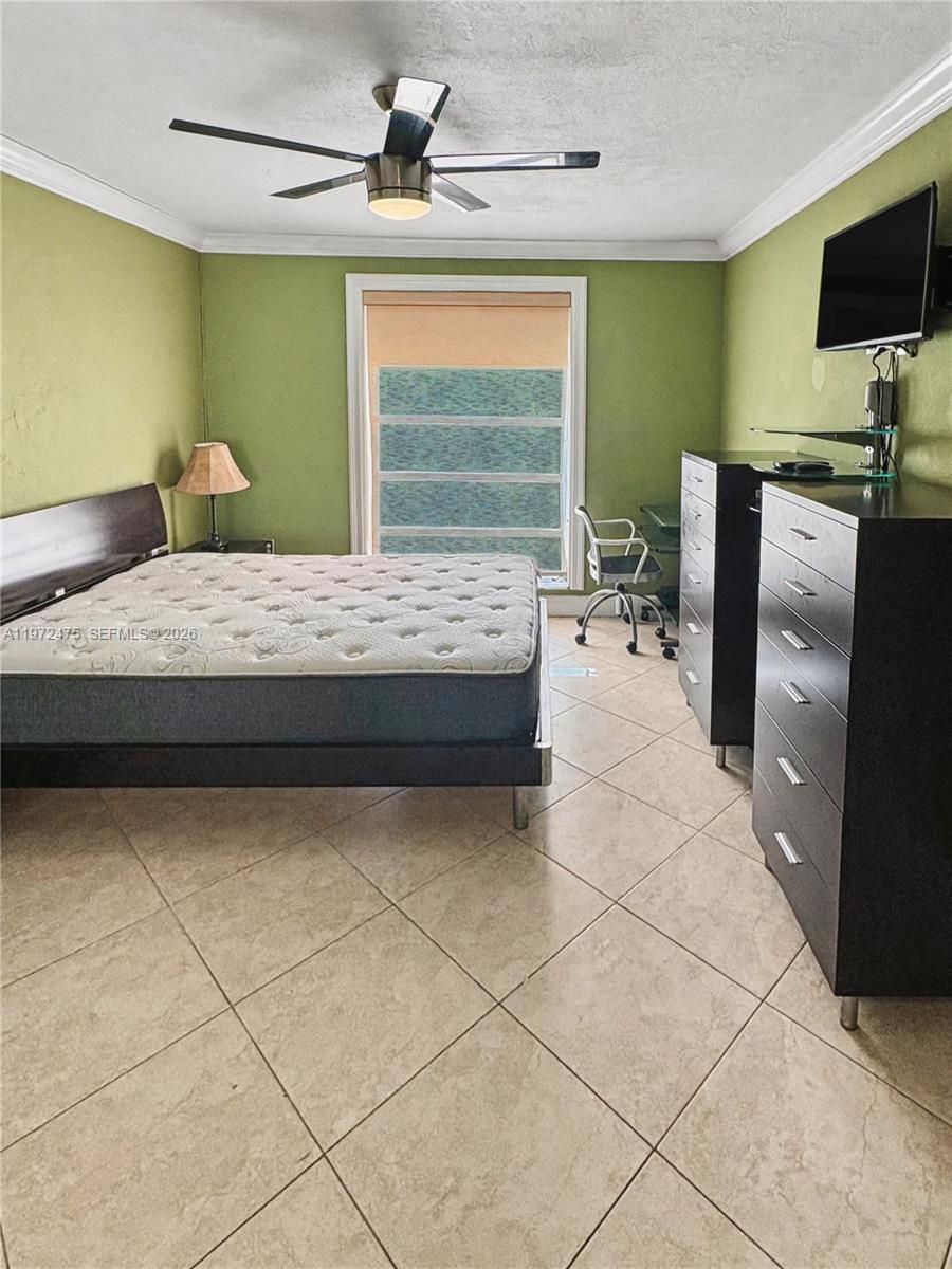 A bedroom features green walls, a bed, two black dressers, and a ceiling fan — 9417 SW 76th St # X36, Miami FL 33173, MIAMI, FL