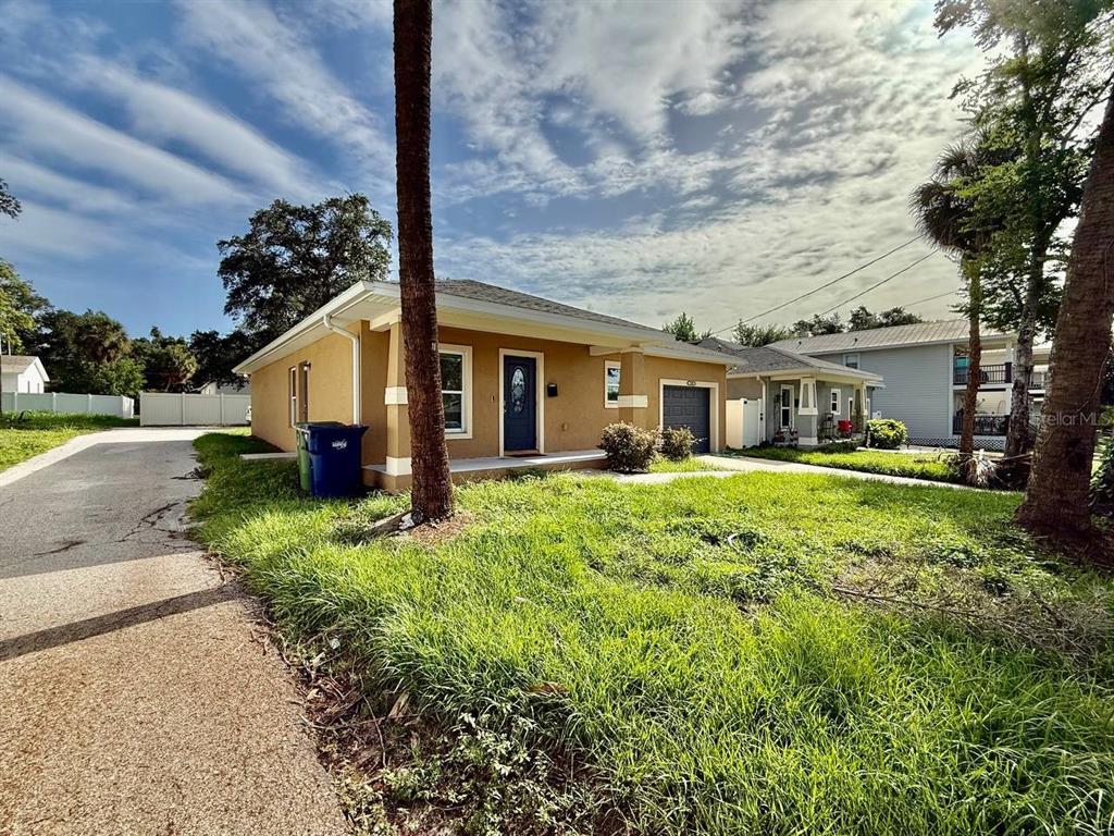 A tan, single-story house with a dark front door and a driveway on the left — 2904 E COLUMBUS DRIVE, TAMPA, FL