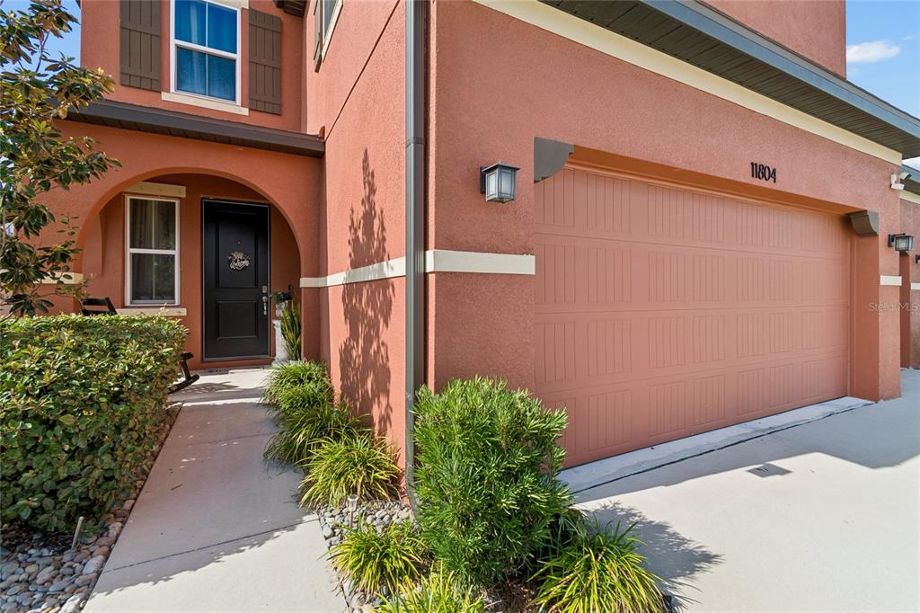 The exterior of a two-story home features a terracotta-colored facade and a two-car garage — 11804 BLUEGRASS FIELD COURT, RIVERVIEW, FL