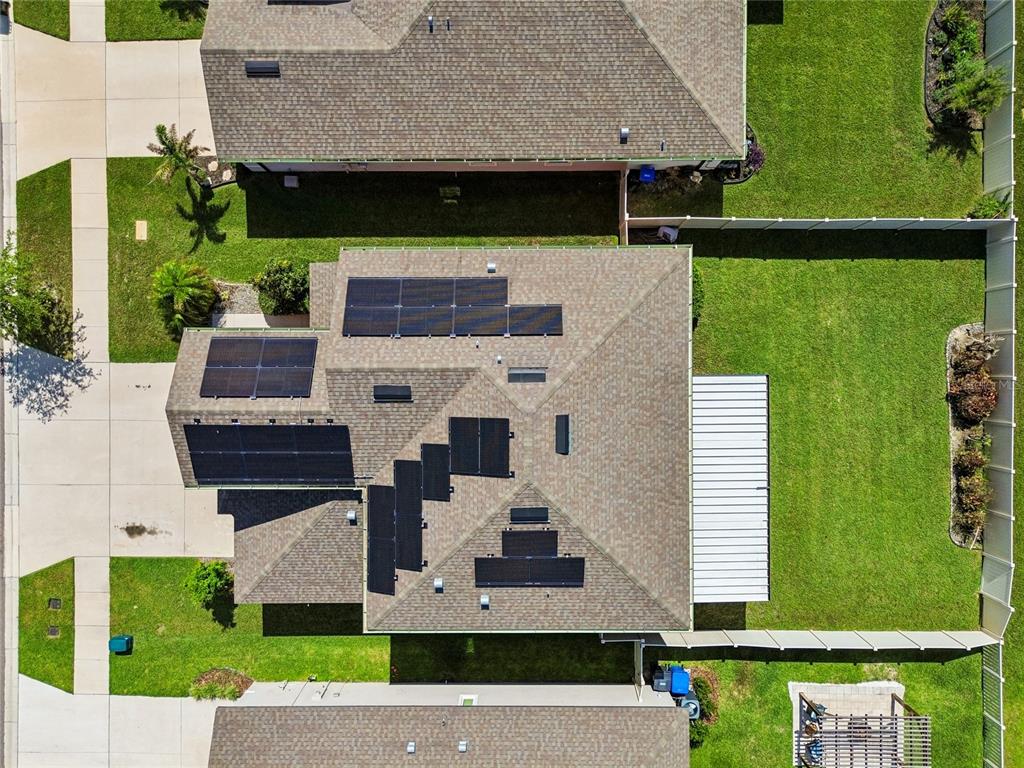 An aerial view shows a residential house with solar panels installed on the shingled roof — 11804 BLUEGRASS FIELD COURT, RIVERVIEW, FL