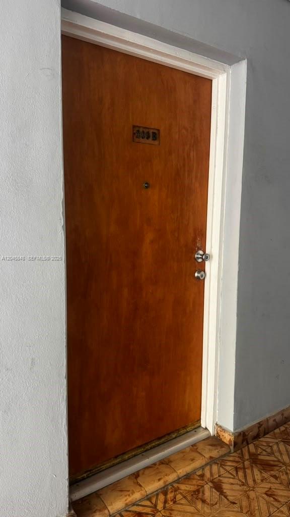 A wooden door with a peephole and a unit number is set in a white frame — 145 SW 30th Ct # 209B, Miami FL 33135, MIAMI, FL