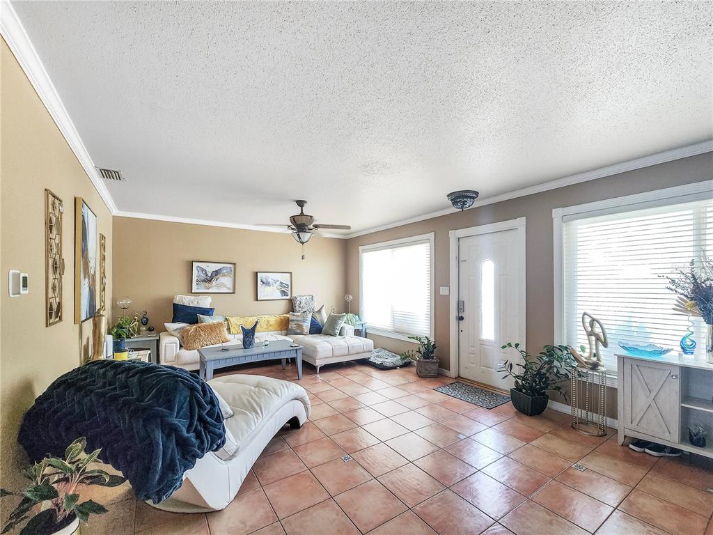 A living room with tile flooring, a white sectional sofa, and a front entry door — 270 BELAIRE COURT, PUNTA GORDA, FL