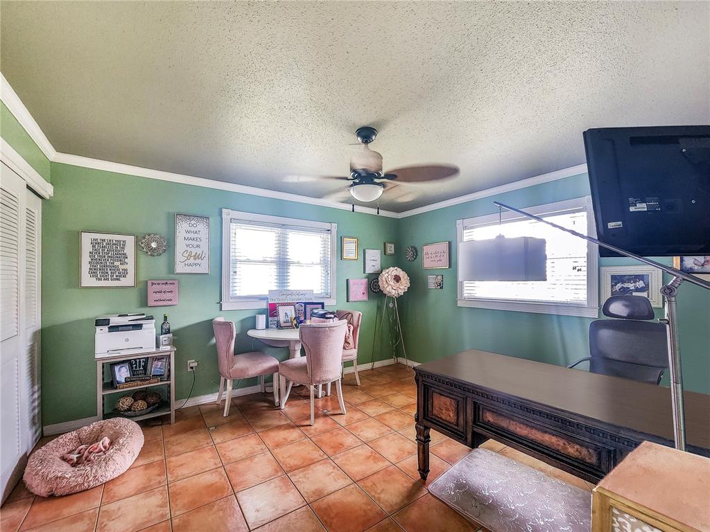 A home office with green walls, tile flooring, a desk, and a small dining set — 270 BELAIRE COURT, PUNTA GORDA, FL