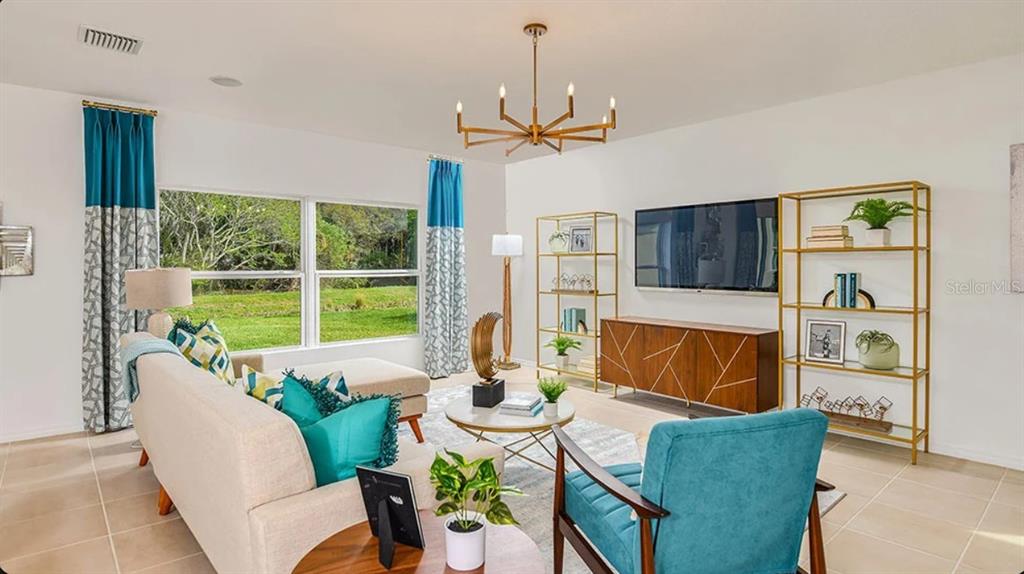 A living room features a beige sofa, teal armchair, gold shelving, and a large window — 13840 SHELLMORE AVENUE, PALMETTO, FL