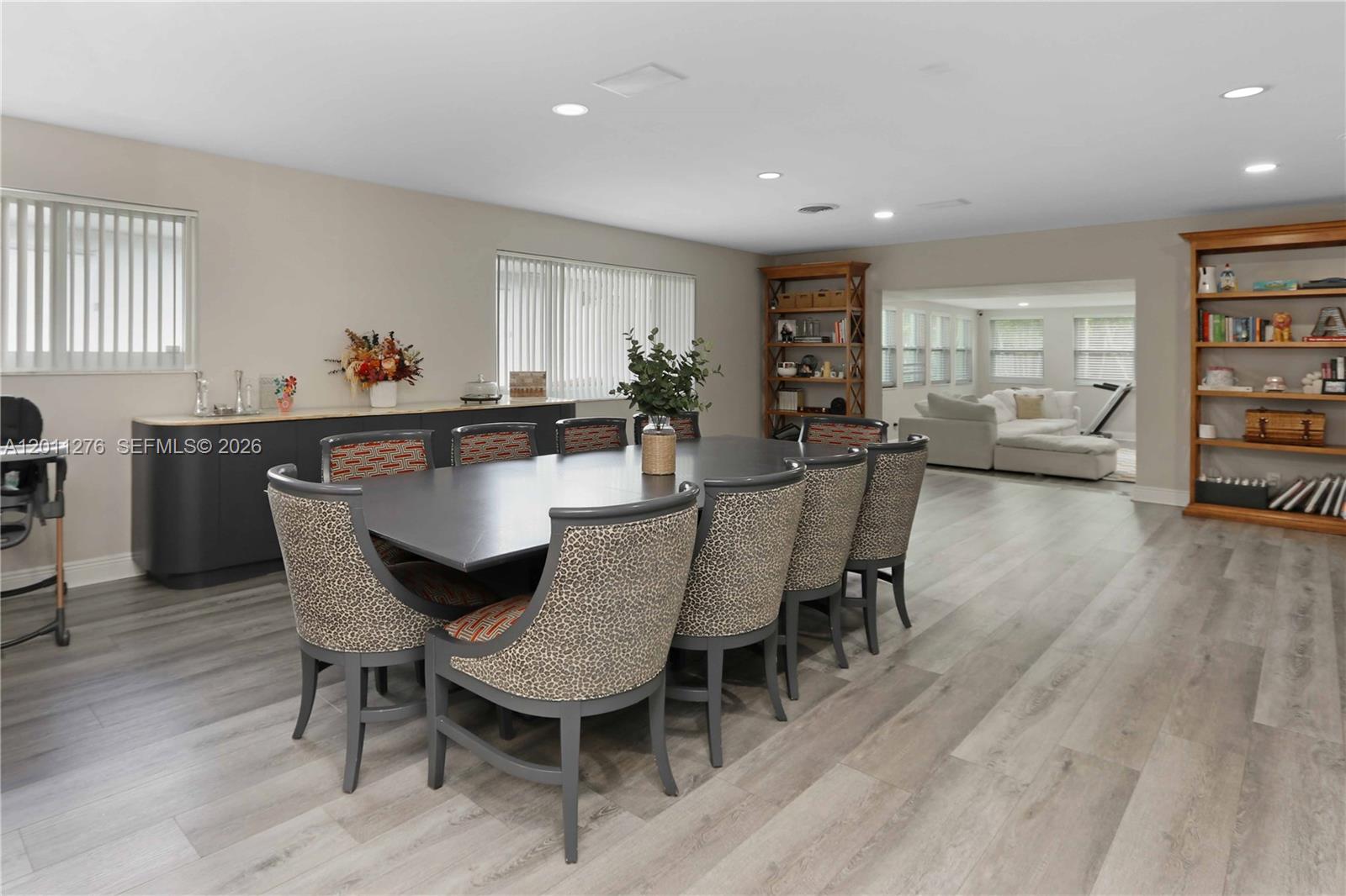 A dining room features a long table with leopard-print chairs and light wood flooring — 1333 Tyler St, Hollywood FL 33019, HOLLYWOOD, FL