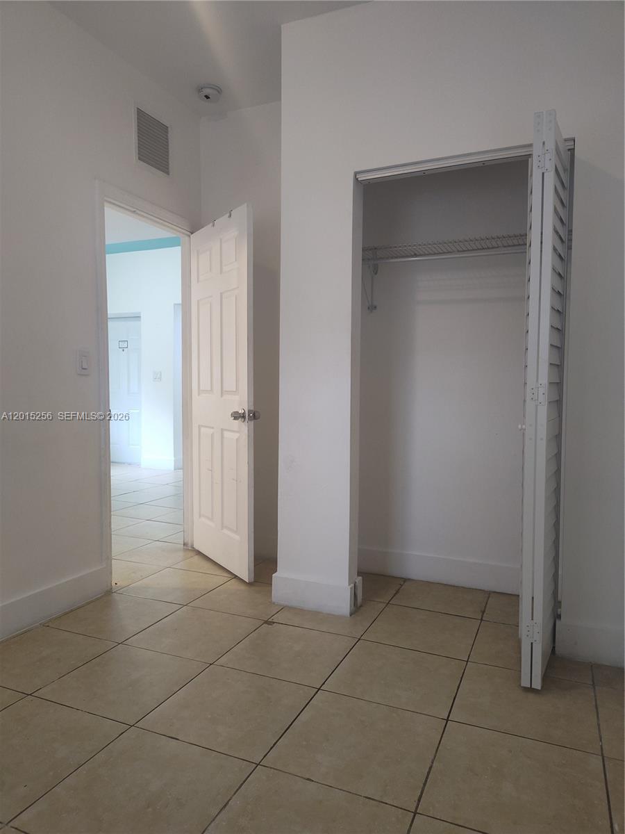 A room with beige tile flooring features an open closet and a doorway leading elsewhere — 8028 NW 5th Ct Rear, Miami FL 33150, MIAMI, FL