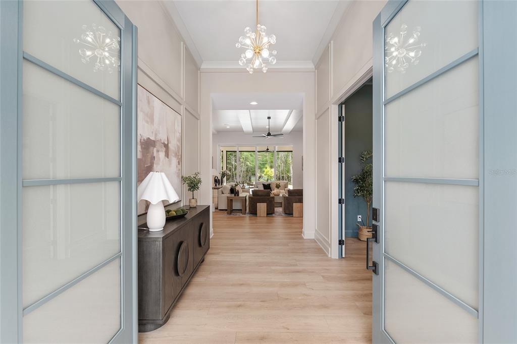 A view through double glass doors into a foyer with light wood floors and paneling — 5990 NW 88TH WAY, GAINESVILLE, FL