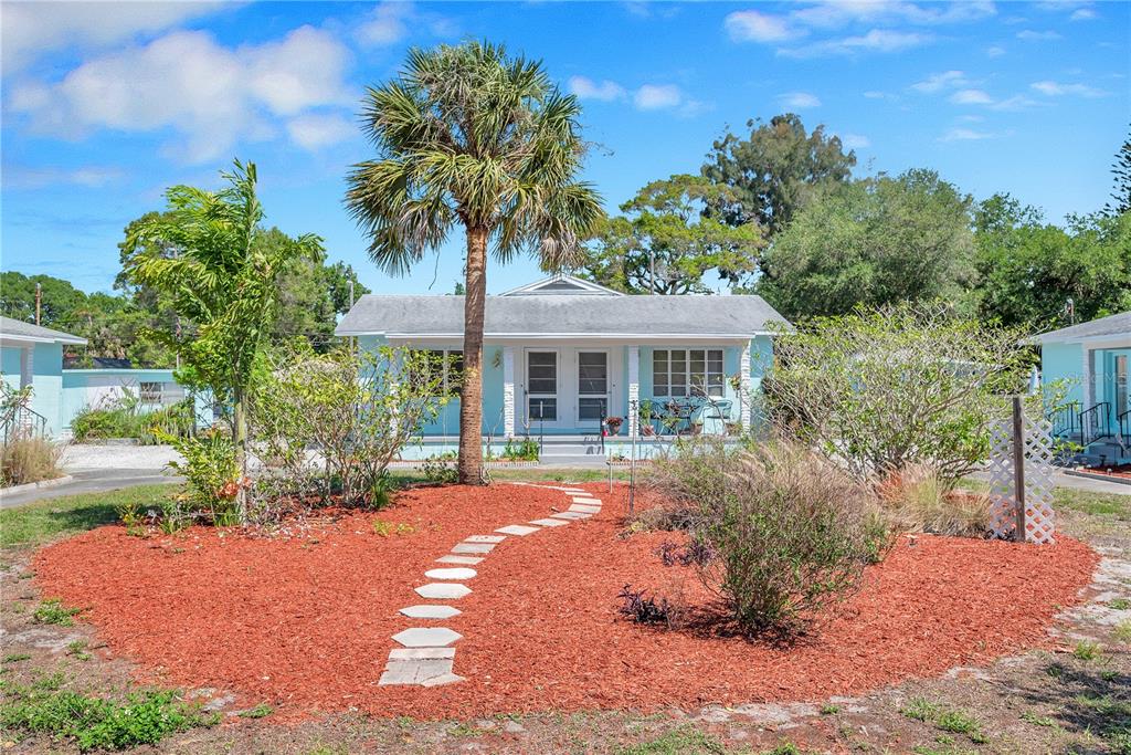 A light blue cottage with a palm tree and a curved stone path in front — 5027 28TH AVENUE S, GULFPORT, FL