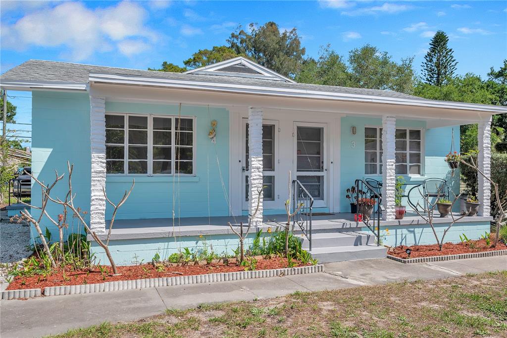 A light blue single-story house features a covered front porch with white brick columns — 5027 28TH AVENUE S, GULFPORT, FL
