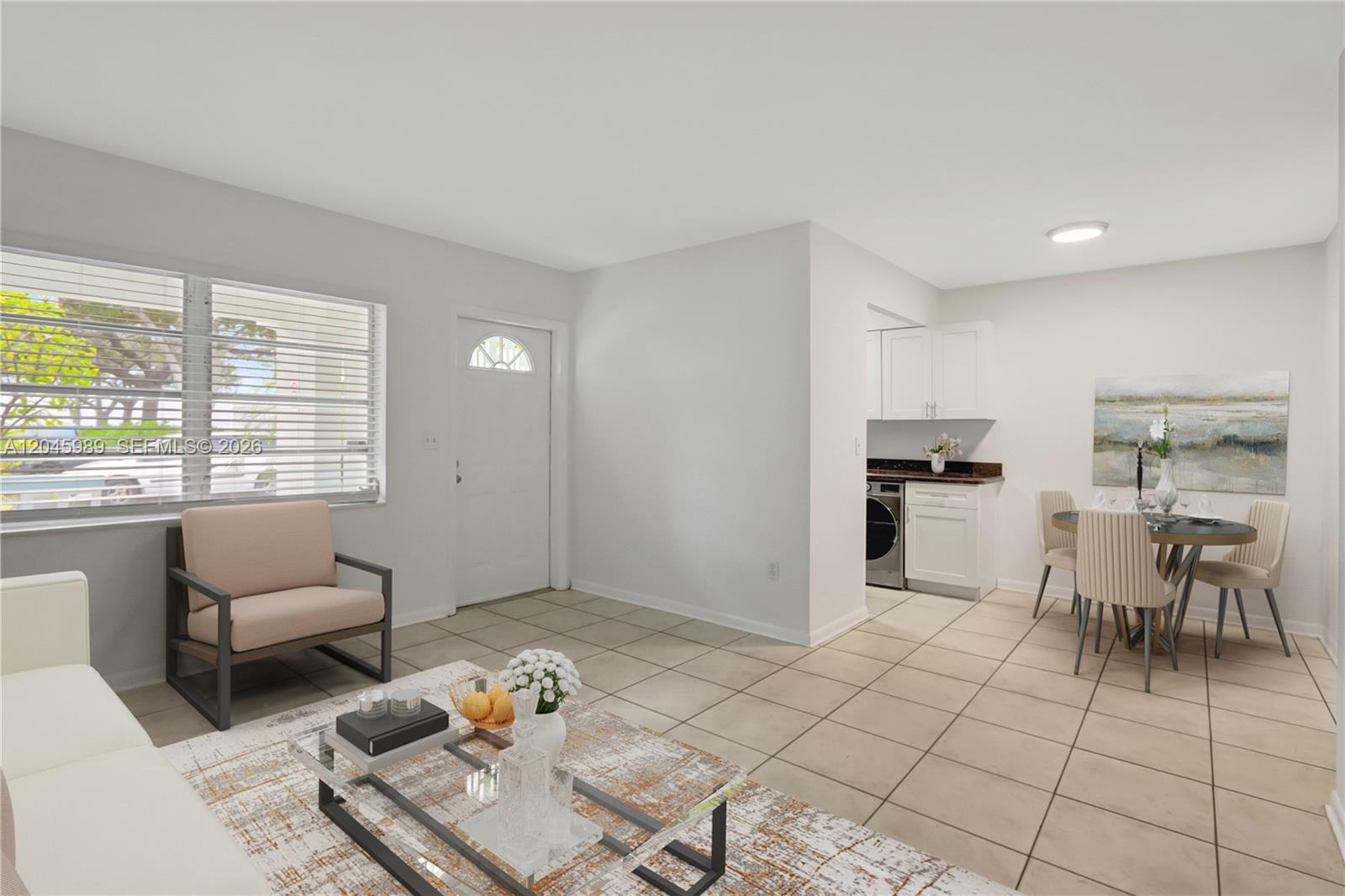 A living and dining area features tile flooring, a glass coffee table, and a laundry nook — 202 N K St # 7, Lake Worth FL 33460, LAKE WORTH, FL