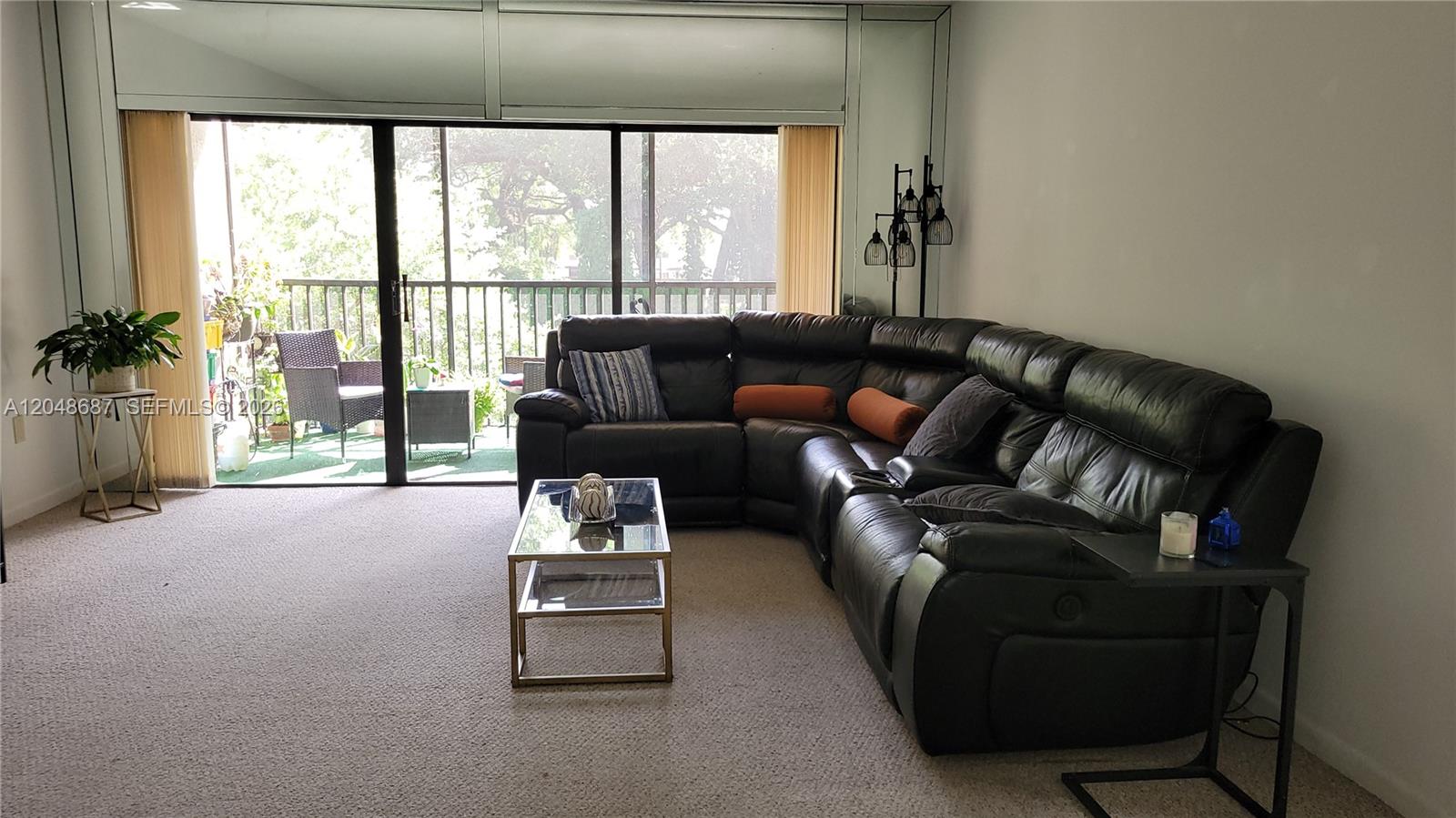 A living room features a black leather sectional sofa, a glass coffee table, and a balcony — 461 Ives Dairy Rd # 2, Miami FL 33179, MIAMI, FL
