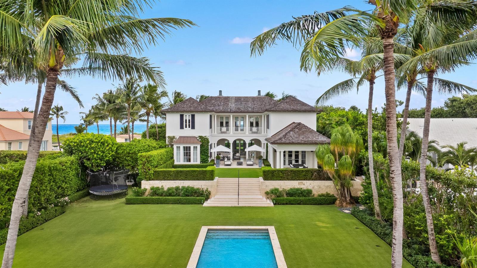A two-story white house with a pool, manicured lawn, and palm trees at the beach — 102 Reef Road, Palm Beach FL 33480, PALM BEACH, FL