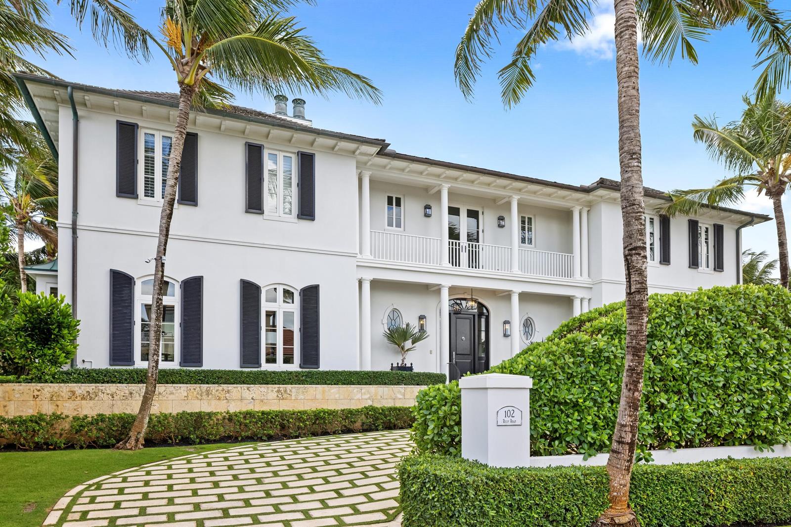 A two-story white house with black shutters and a paved driveway behind a hedge — 102 Reef Road, Palm Beach FL 33480, PALM BEACH, FL