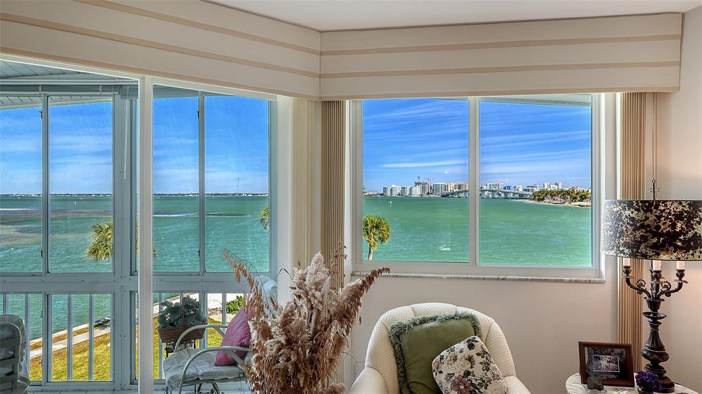 A living room with large windows overlooking a bay, a bridge, and a city skyline — 777 JOHN RINGLING BOULEVARD UNIT 32, SARASOTA, FL