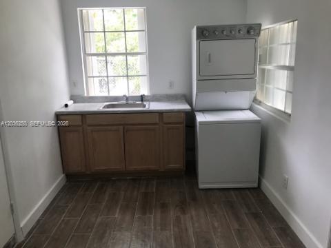 A laundry room features a sink, wooden cabinets, and a stacked washer and dryer unit — 3244 SW 3rd St # L, Miami FL 33135, MIAMI, FL