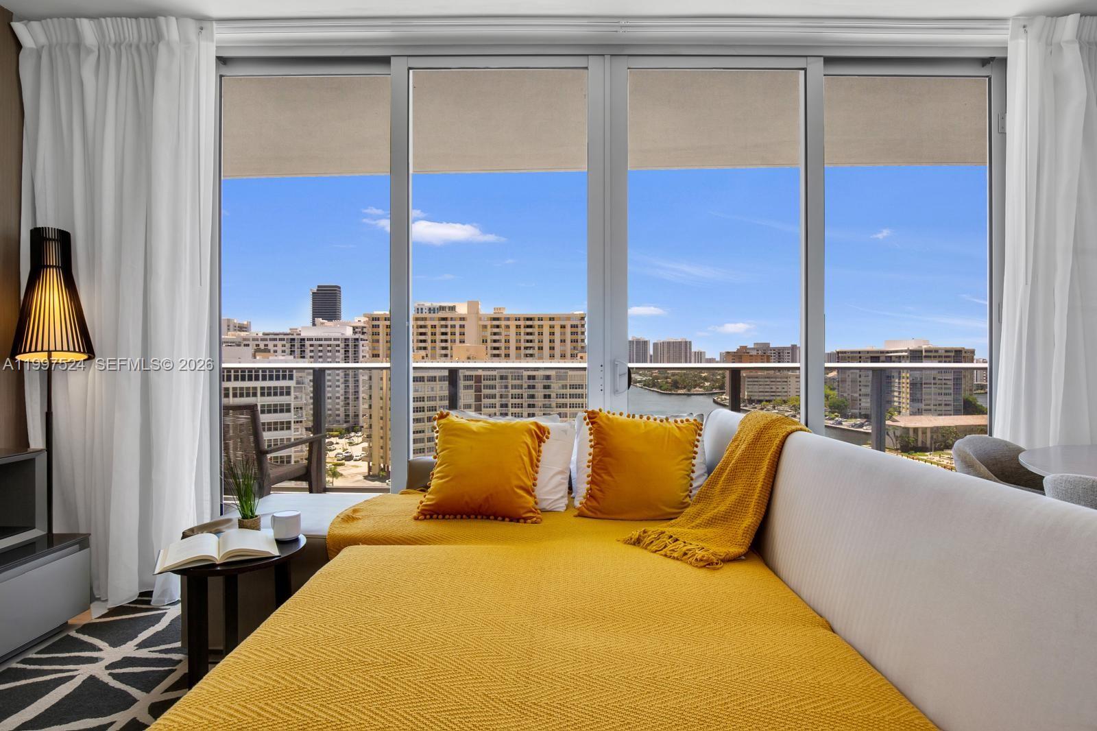 A living area features a yellow daybed facing a balcony with city and water views — 4010 S Ocean Dr # R708, Hollywood FL 33019, HOLLYWOOD, FL