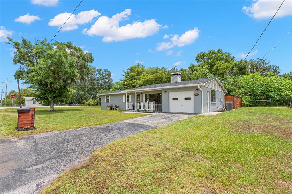 A gray single-story house with a white garage door and a white picket fence — 13839 GLEN HARWELL ROAD, DOVER, FL