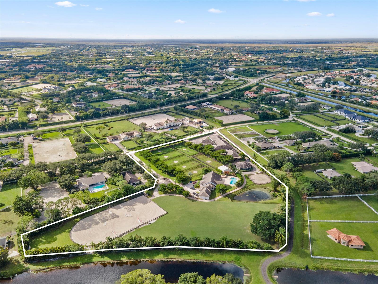 An aerial view shows a large residential estate with a riding arena and swimming pool — 2388 King Terrace, Wellington FL 33414, WELLINGTON, FL
