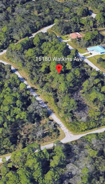 An aerial view shows a wooded, undeveloped lot marked by a red map pin — 15180 WATKINS AVENUE, PORT CHARLOTTE, FL