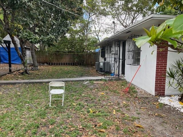 A white folding chair sits on a grassy backyard next to a white house — 800 NW 29th Ter, Miami FL 33127, MIAMI, FL