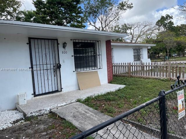 A white house exterior features a black security door and a fenced yard — 800 NW 29th Ter, Miami FL 33127, MIAMI, FL